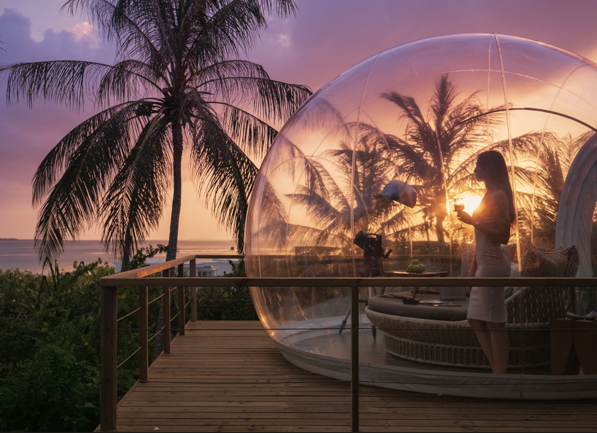 The glamping bubble at night. A transparent sleeping pod under open sky, private chef and sauna on site, no equivalent elsewhere in the atoll.