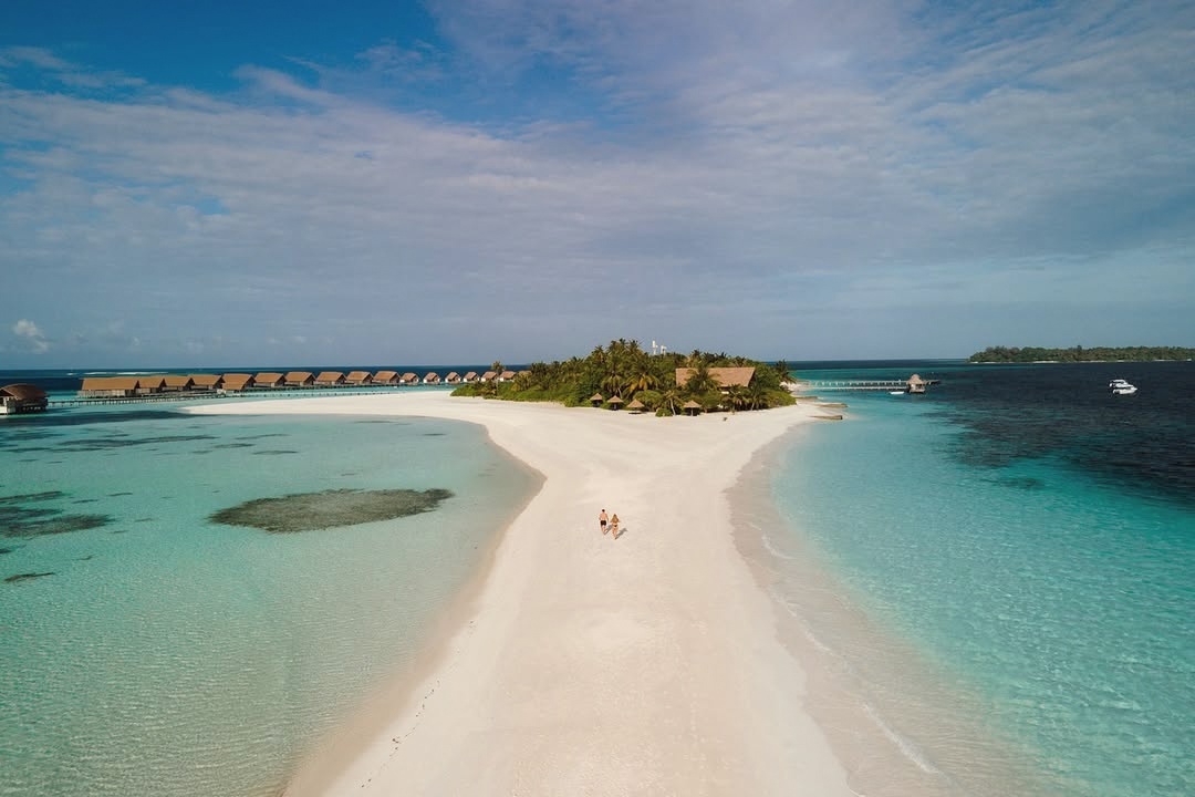 The pool and main island from the water. The scale is deliberately contained: thirty-three villas means the pool and dining areas are never crowded.