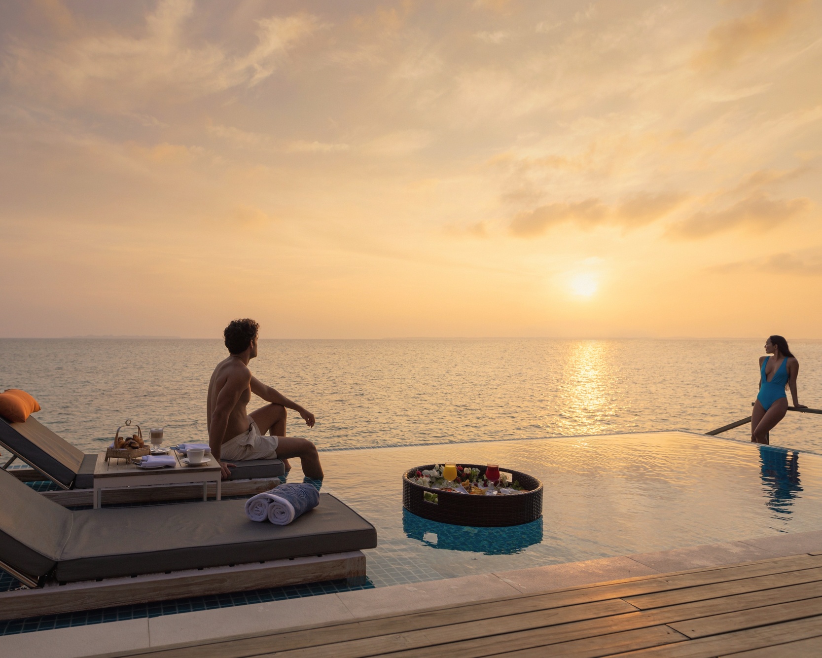 A water villa at the lagoon edge. The deck extends directly over the water, with steps down to the reef below.