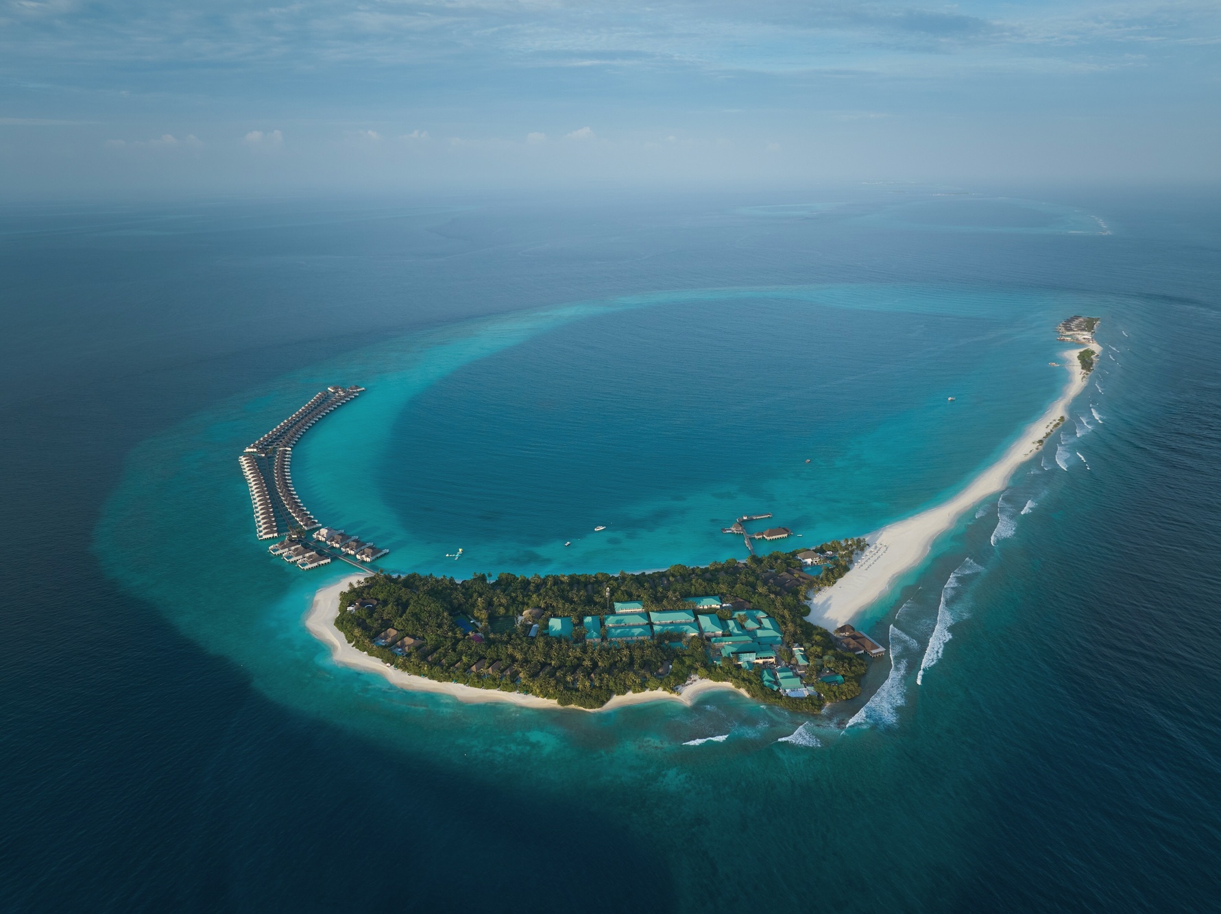 Kanufushi Island from above. The resort occupies its own island in Baa Atoll, with the sandbank extending visibly from the southern tip.