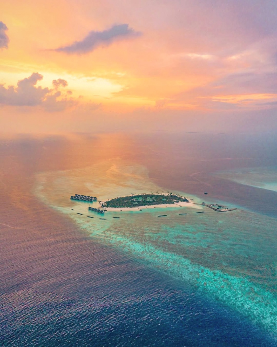 Fushifaru from above. A single coral island on the northeast border of Lhaviyani Atoll, scaled to a small villa count and surrounded by a productive reef.