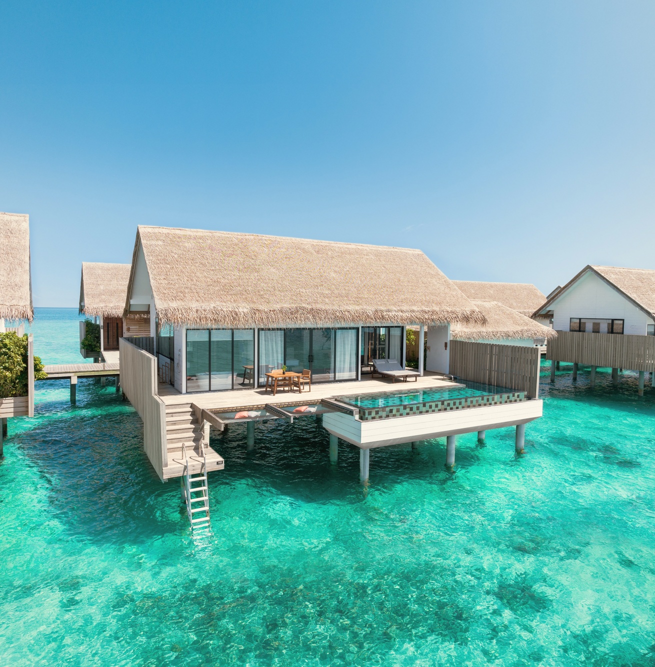 An overwater pool villa from the deck. The private pool sits at the lagoon edge, with direct water access below.