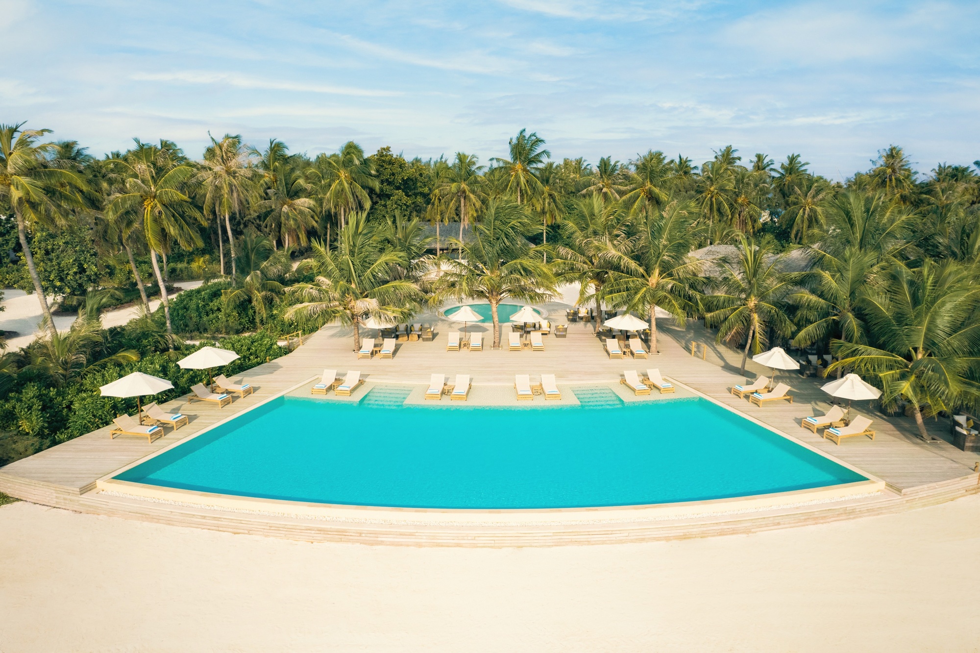 The pool and garden zone at the centre of the island. Lush tropical plantation frames the main pool area.