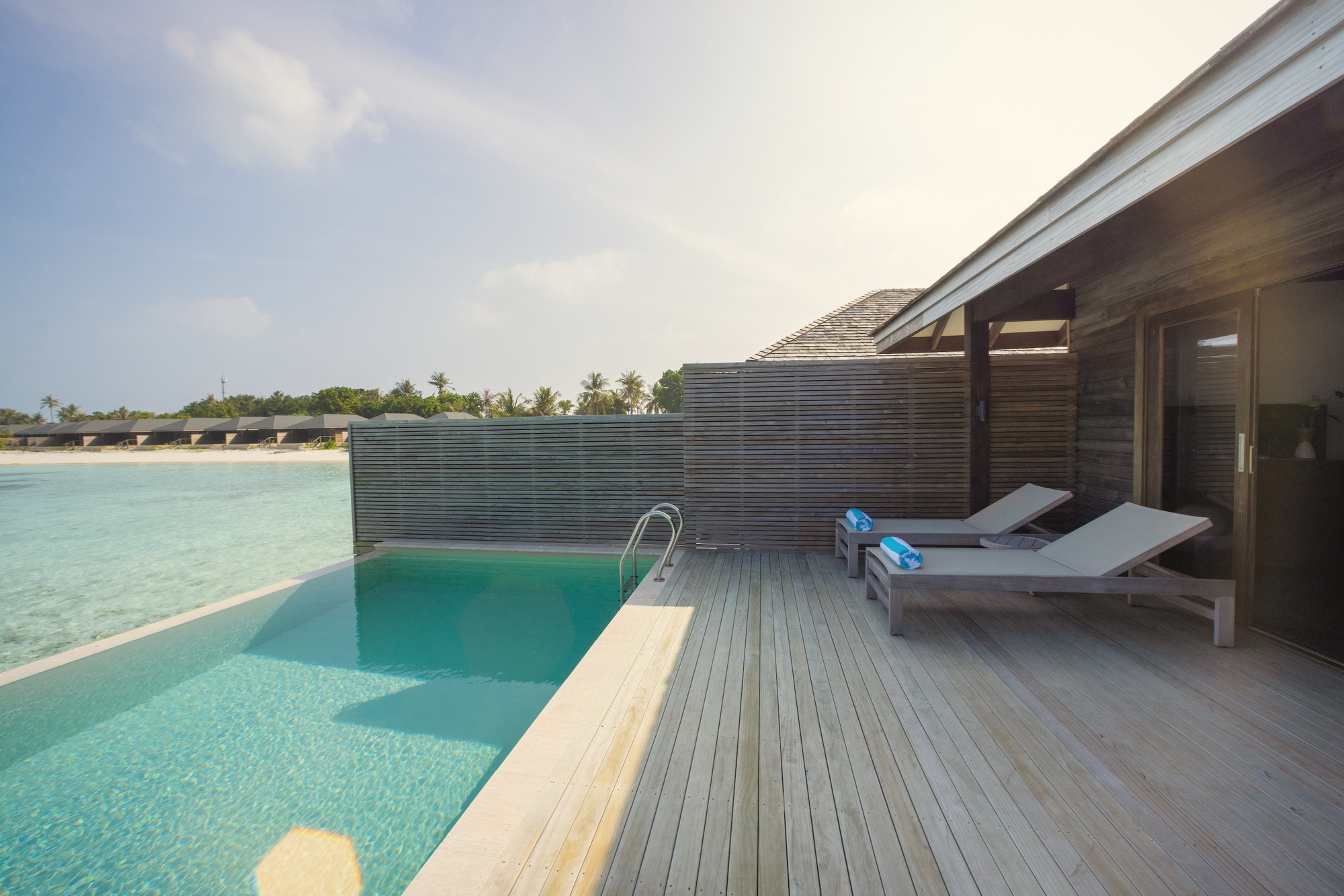 A Mabin Water Pool Villa from the deck. The overwater configuration sits directly above the lagoon, with pool access at the edge.