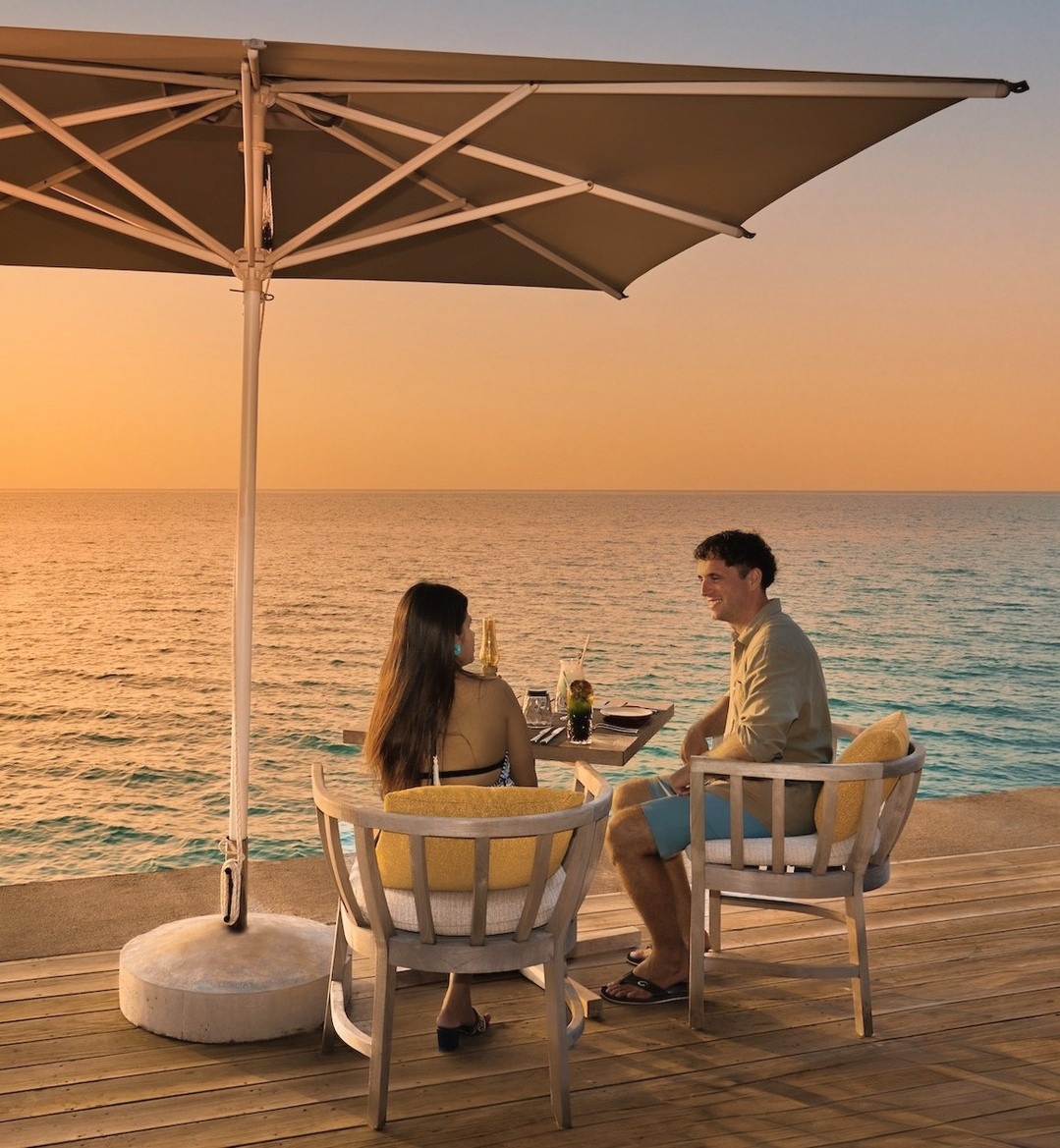 Dining at the water's edge. The resort's restaurant positions guests directly above the lagoon with open-sided service.