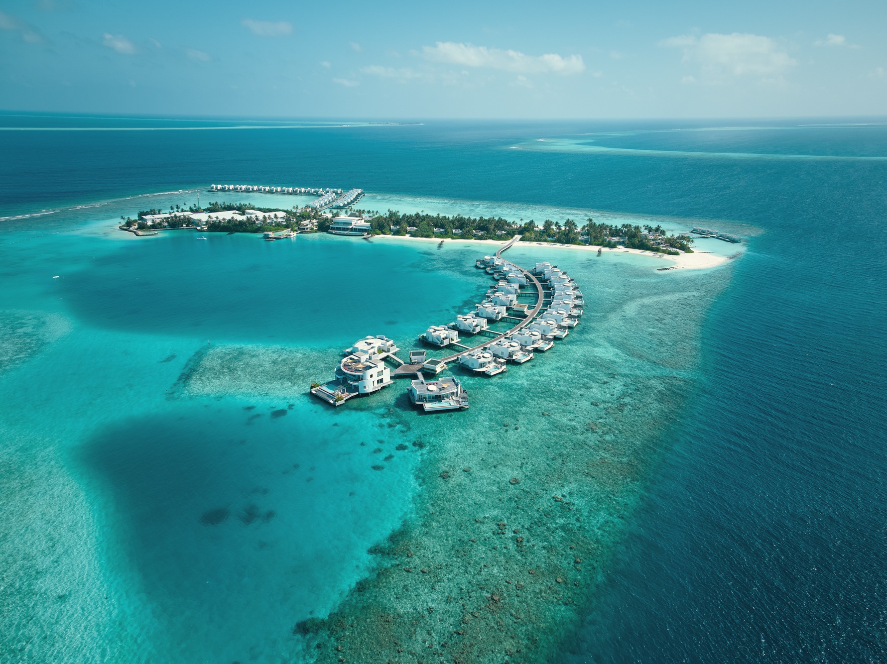 Olhahali Island from above. The resort occupies its own private island in North Malé Atoll, the villa footprint visible against the lagoon.