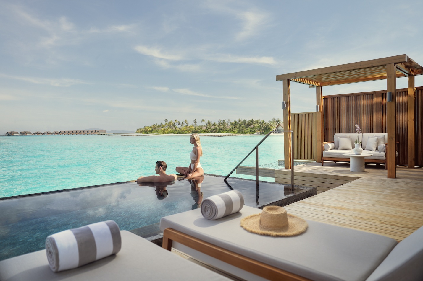 An overwater pool villa exterior. The treetop-and-overwater fusion architecture positions the villas within the island canopy rather than apart from it.