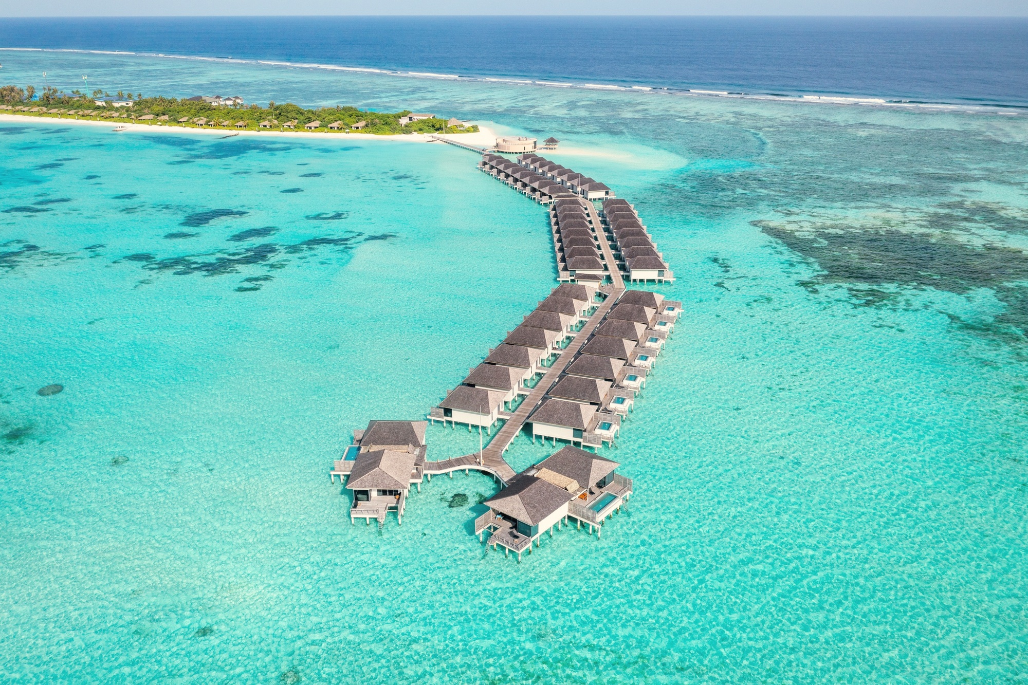 Thilamaafushi from above. The nine-hectare island sits in Lhaviyani Atoll, its reef edge and mangrove fringe visible from the air.