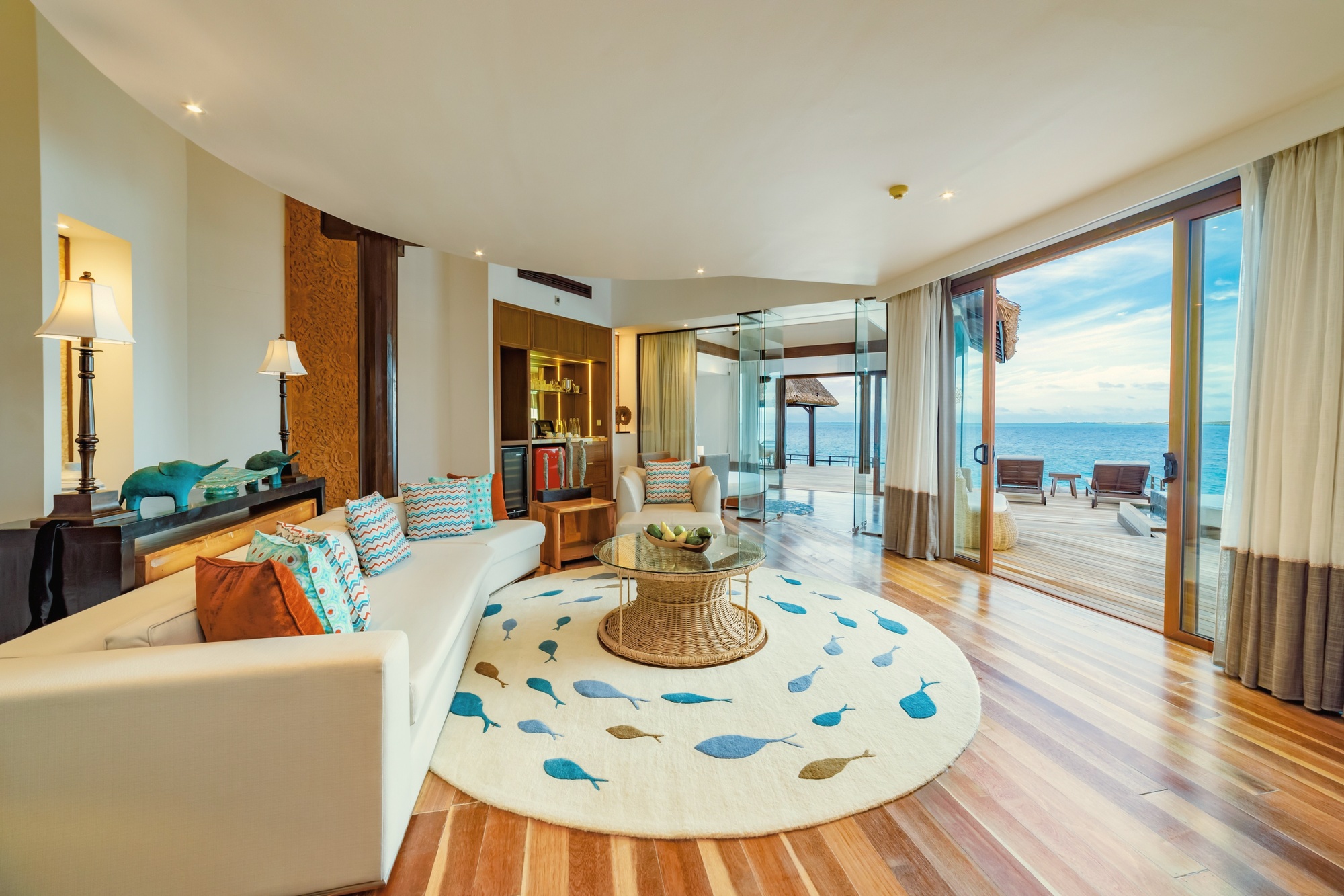The interior of an overwater villa at Bolifushi. OZEN COLLECTION finishes sit above the standard all-inclusive category, with open-plan living and direct lagoon access.