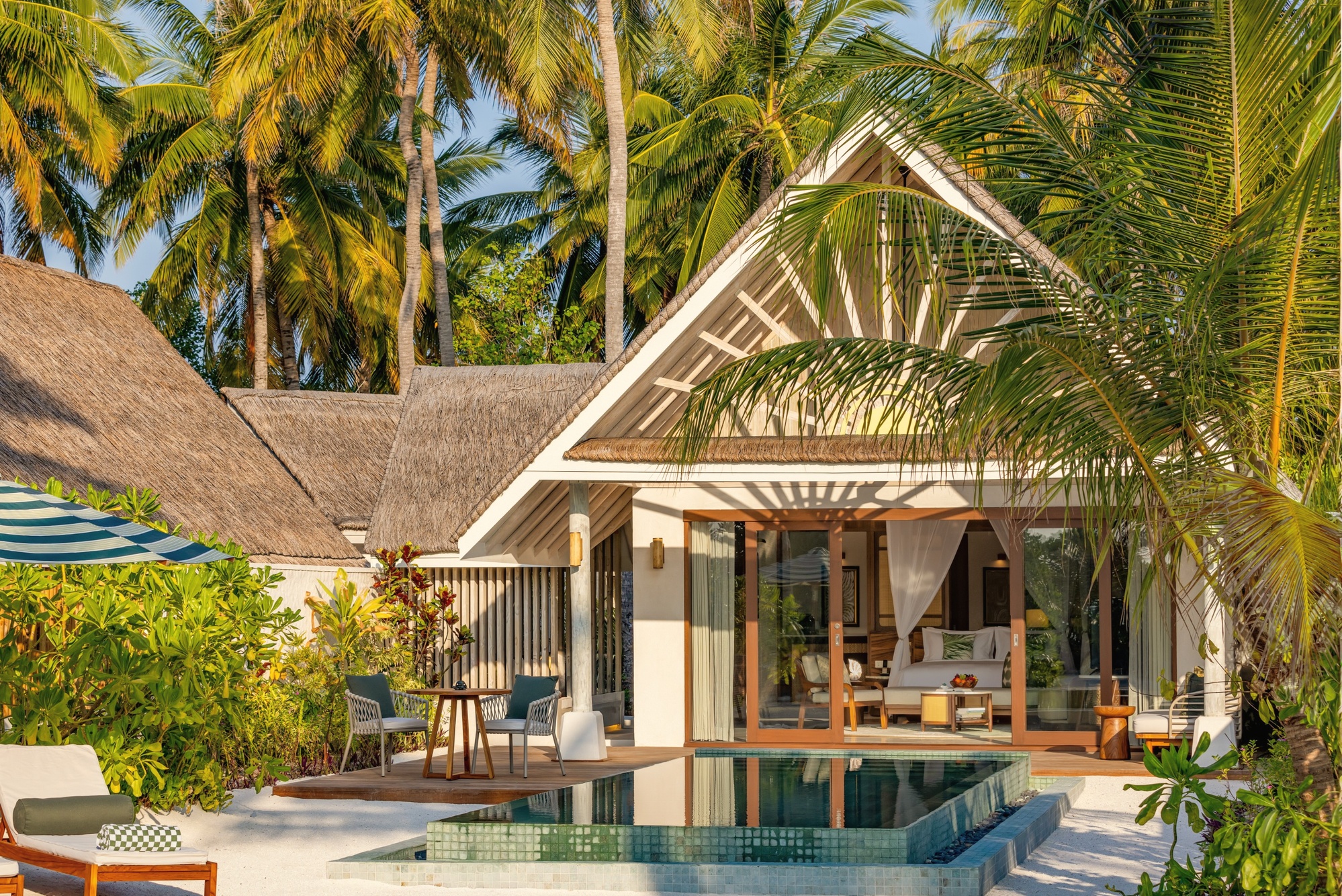 A beach pool villa from the water's edge. The beach villas sit directly on the sand with private pool access and lagoon views.
