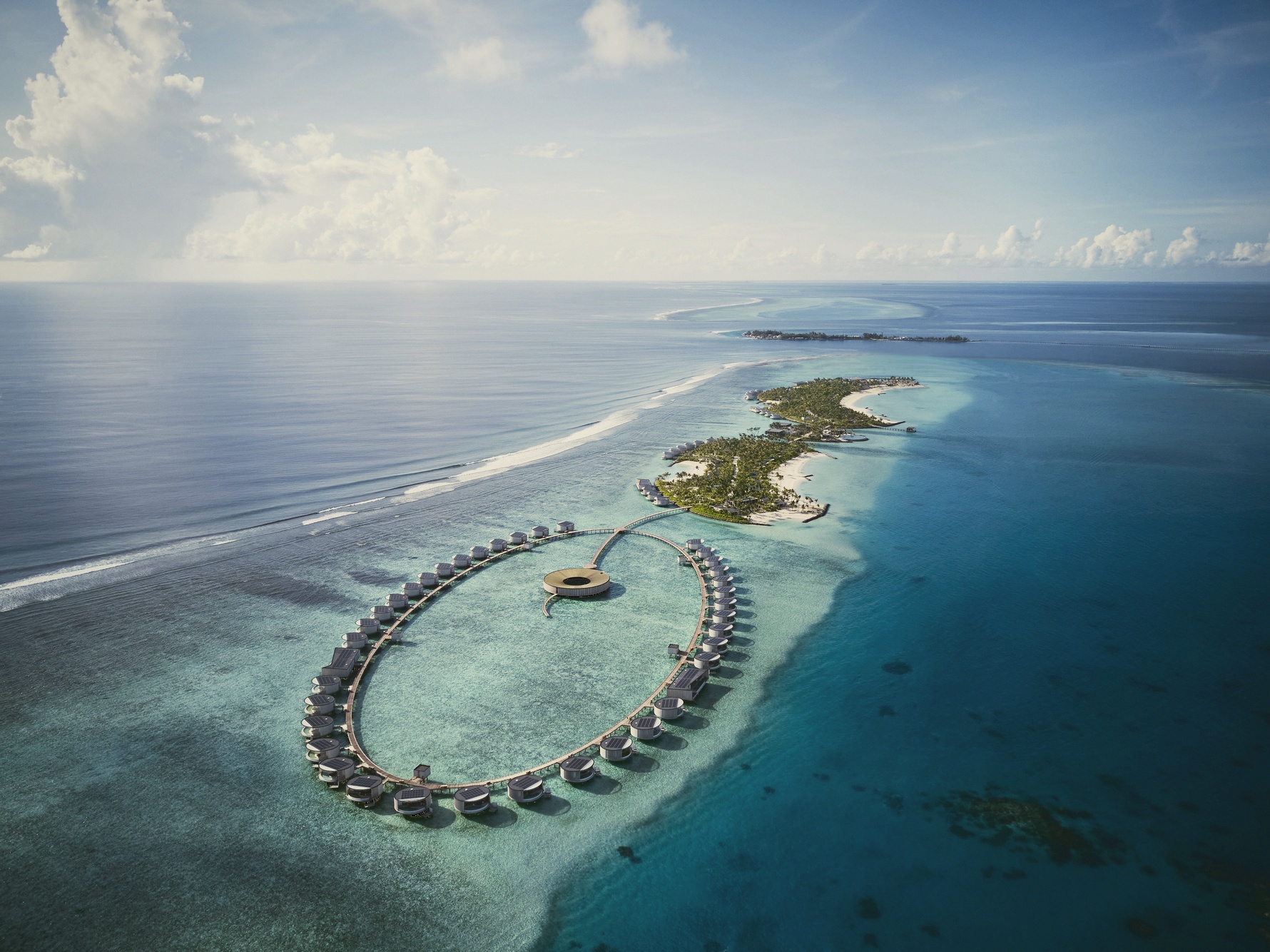 The Ritz-Carlton Maldives from above. The resort occupies a sheltered beach cove on Fari Islands North, separated from the open lagoon by its own natural enclosure.