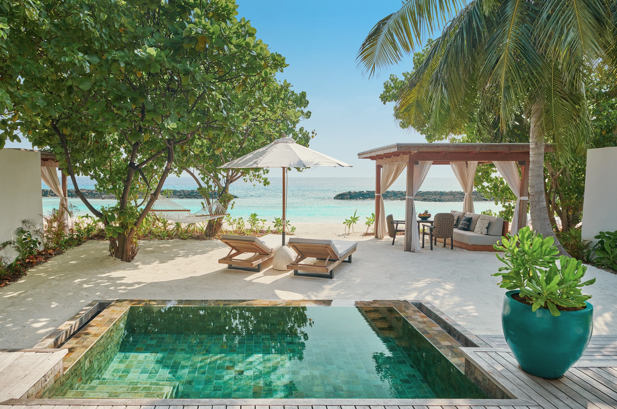 A beach villa exterior at the lagoon edge. The all-villa configuration means every guest has a standalone category with direct beach or garden access.