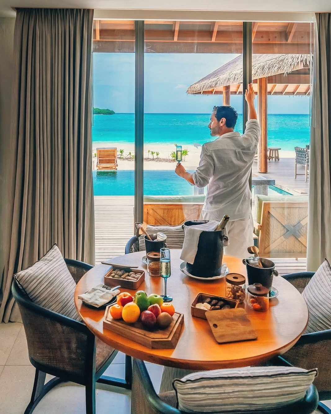 The interior of a beach villa at Kanuhura. Generous proportions, natural materials, and a private pool framed by mature vegetation.