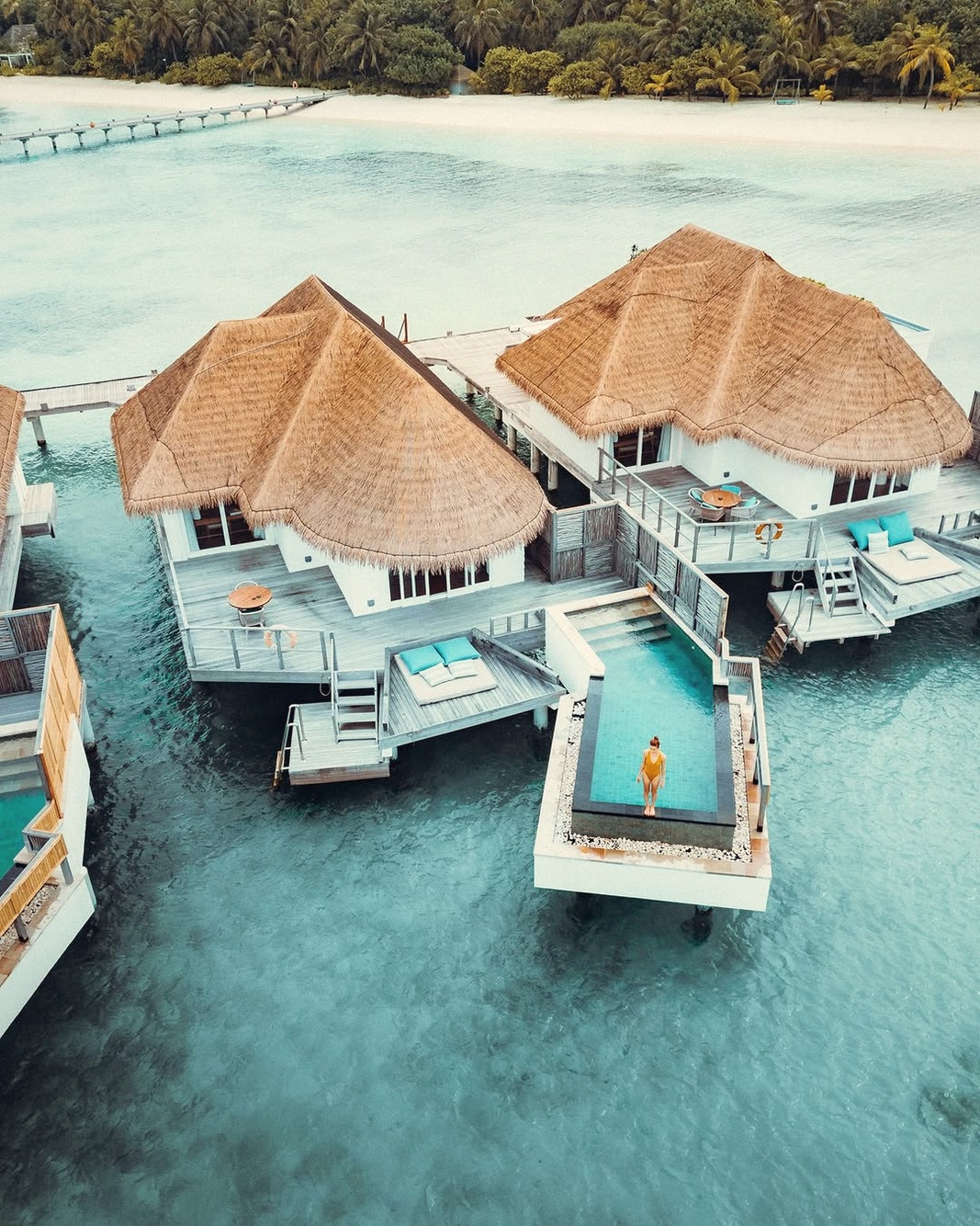 An overwater pool villa from the deck. The lagoon water in Lhaviyani is clear and shallow, and the villa deck is its own room.