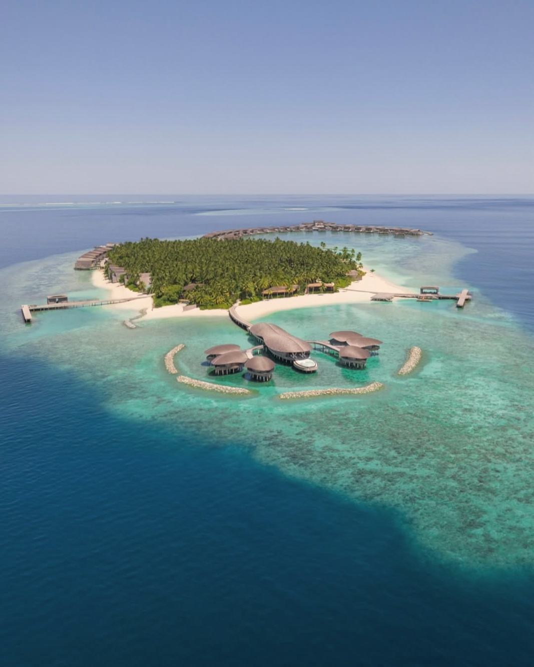 Vommuli Island from above. A nine-hectare private island in Dhaalu Atoll, the resort occupies the full landmass with overwater villas extending across the lagoon.