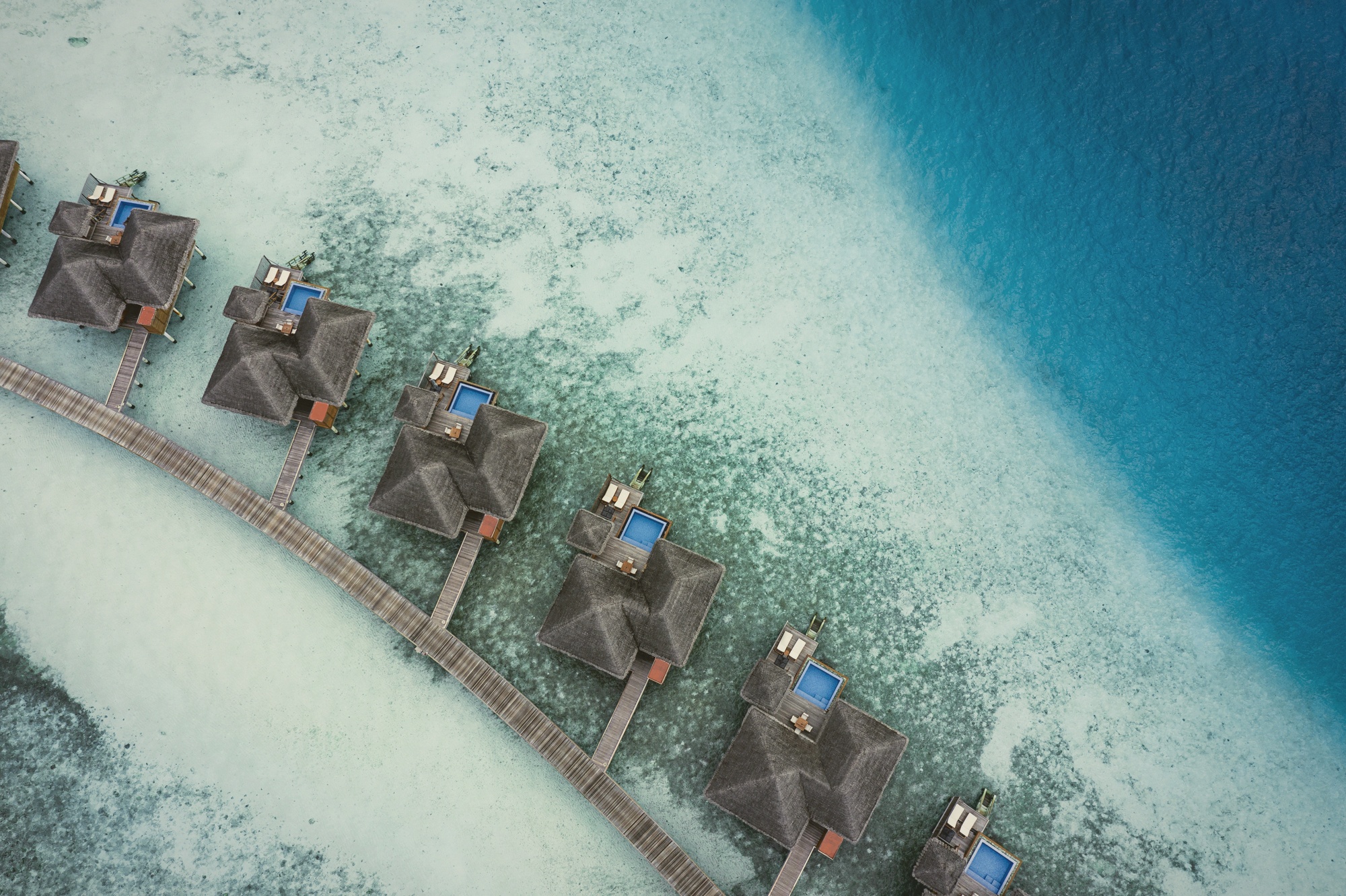 Huvafen Fushi from above. A compact private island in North Malé, the lagoon wrapping the entire footprint.