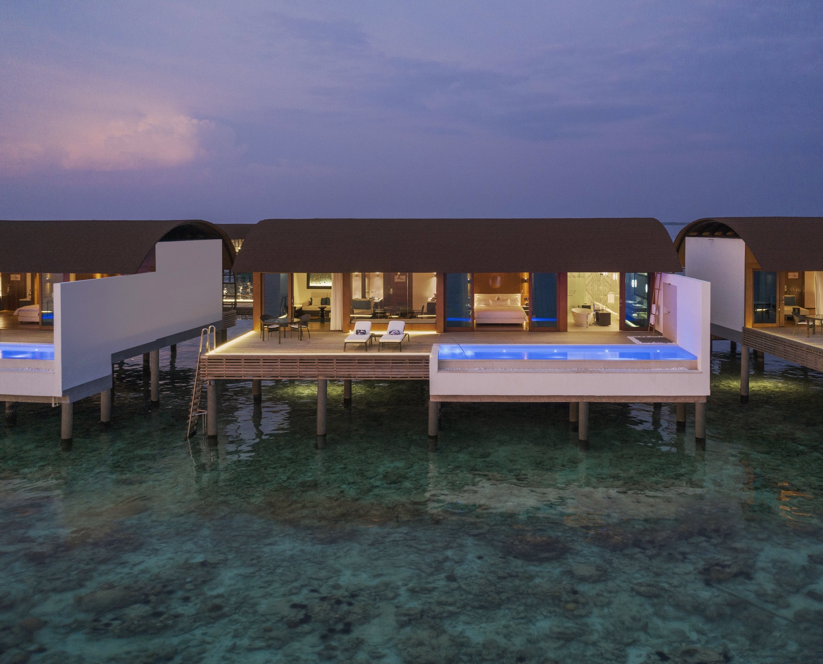 An overwater pool villa from the deck. The lagoon edge is its own room, and the Baa Atoll water clarity is consistent year-round.
